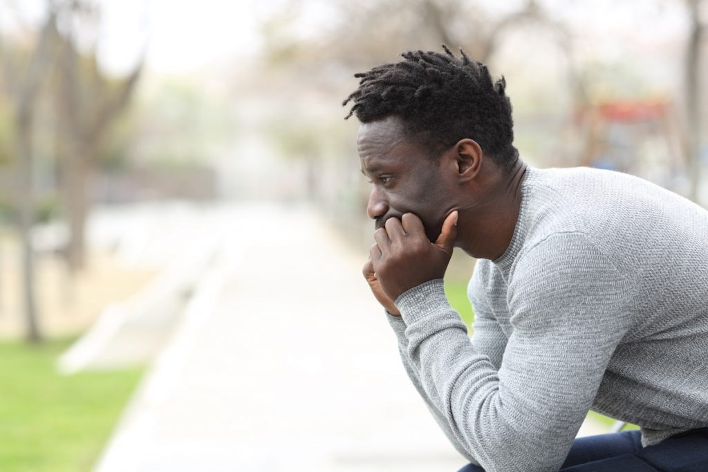 Pensive serious black man looking away on a park / blog - myths about erectile dysfunction